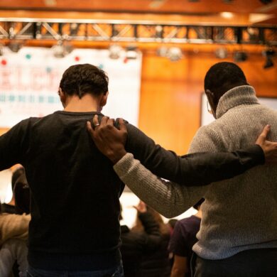Men embracing in church